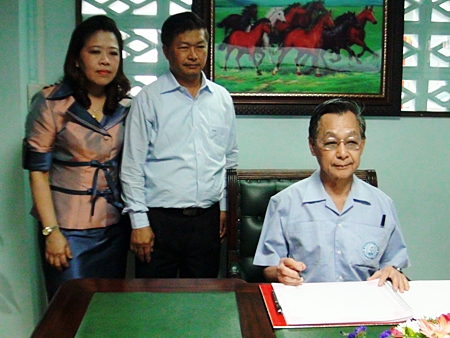 Former Prime Minister Chuan Leekpai signs the guestbook at the new Democrat Party headquarters in Chonburi.